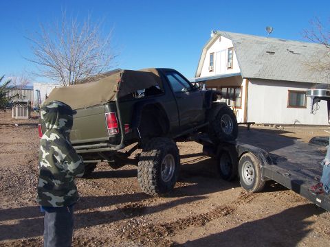 1981 Ford F-150 - A heavily modified pickup truck is being loaded onto a trailer, with a person observing the process.