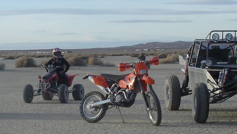 2004 Ford F-150 - An orange dirt bike and a red ATV are parked in a desert area with a dune buggy in the background.