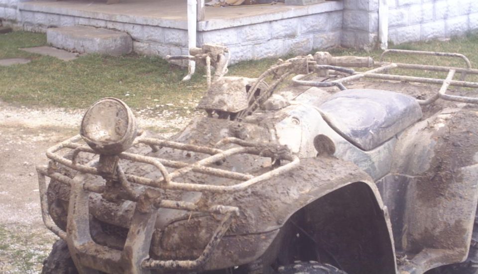 Mud-covered ATV front view