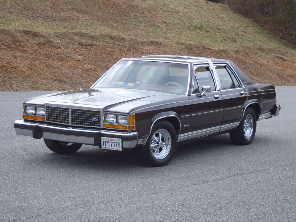 Two-tone brown/silver Ford LTD Crown Victoria sedan, front 3/4 view, on pavement