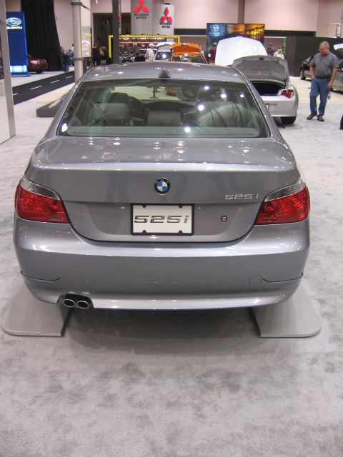 1999 Ford Crown Victoria - A silver BMW 525i is displayed at an auto show with its rear facing the camera.