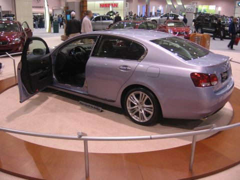 1999 Ford Crown Victoria - A light purple sedan is displayed with its driver's door open at an auto show.