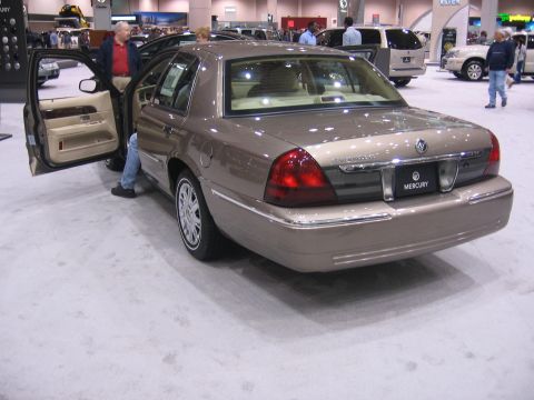 1999 Ford Crown Victoria - A tan Mercury Grand Marquis is displayed with its driver's door open at an auto show.