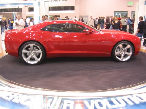 1999 Ford Crown Victoria - A red sports car is displayed on a turntable at an auto show.