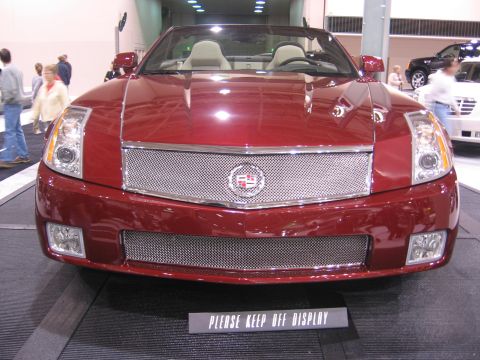 1999 Ford Crown Victoria - Front view of a red Cadillac convertible on display, with a sign reading 'PLEASE KEEP OFF DISPLAY'.