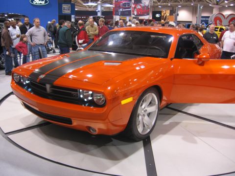 1999 Ford Crown Victoria - An orange Dodge Challenger is displayed with its door open at an auto show.