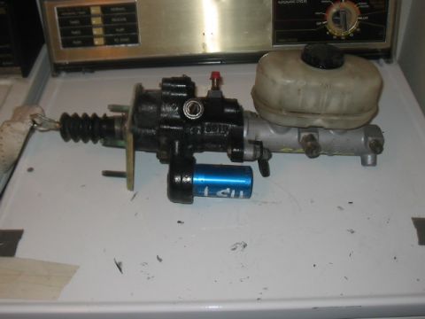 1991 Ford Bronco - Brake master cylinder and reservoir assembly, possibly for a vehicle, with a blue canister attached.