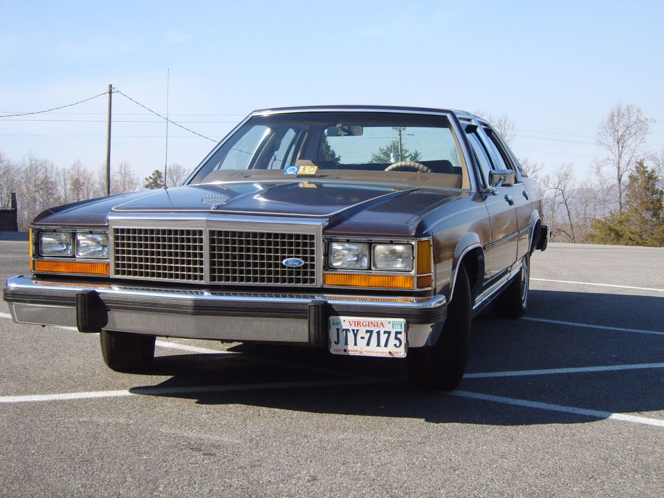 Front view of a dark brown 1980s sedan with a chrome grille and Virginia license plate JTY-7175