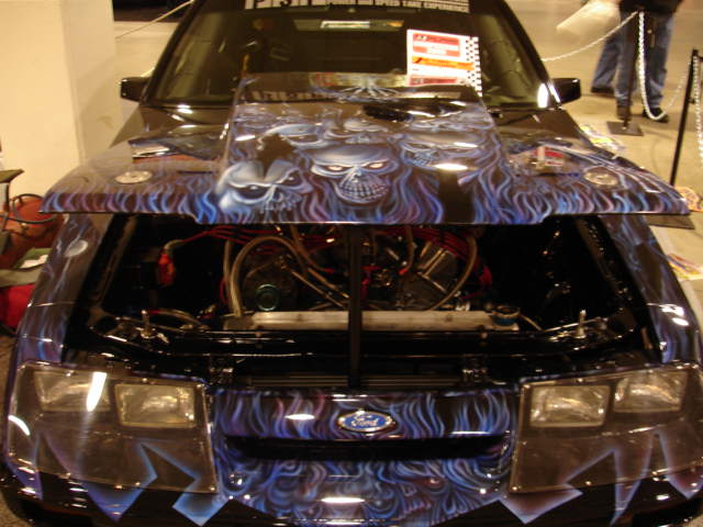 Front view of a black 1981 Ford Mustang with custom skull airbrushing on the hood and grille