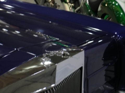 1981 Ford Mustang - Close-up of a blue car's hood chrome trim and a Supermotors.net watermark.