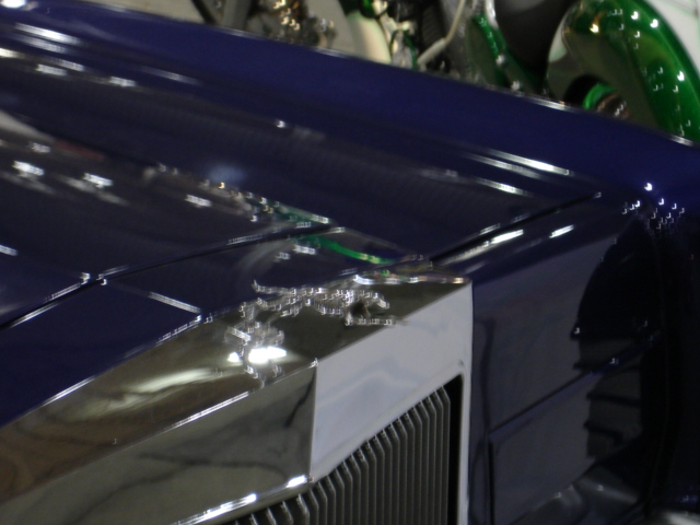 Blue car hood with chrome trim and visible Supermotors.net watermark
