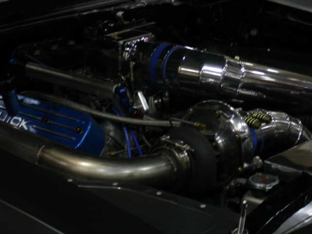 Engine bay with turbocharger and blue valve cover with 'QUICK' text