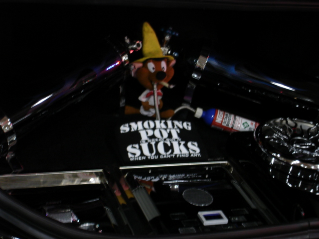 Cartoon character with a yellow hat and cigarette, on a black surface with text and a bottle