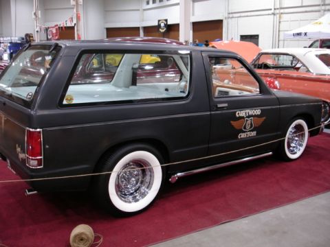 1981 Ford Mustang - Custom black SUV with whitewall tires and chrome wheels displayed indoors.