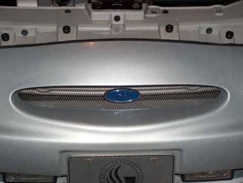 1998 Ford Taurus - Front grille of a 1998 Ford Taurus, showing the blue Ford emblem and mesh insert.