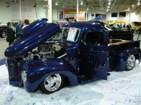 1981 Ford Mustang - A custom pickup truck is displayed with its hood open, revealing the engine and chrome details.