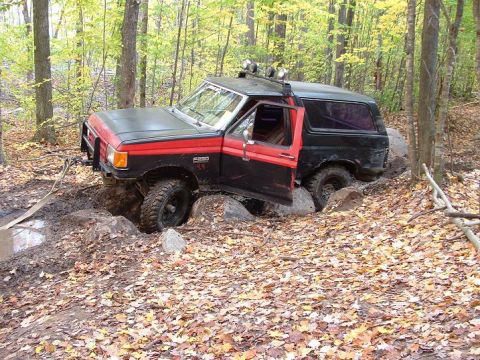1977 Ford F-150 - Ford Bronco navigating difficult terrain off-road.