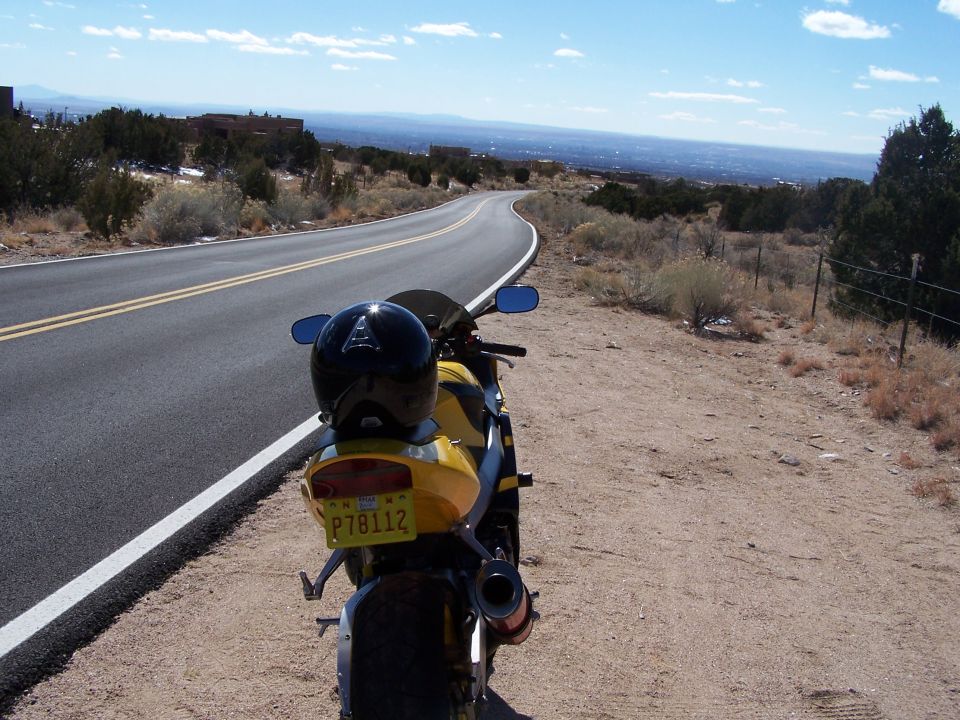 Yellow motorcycle rear view with a helmet on the seat. License plate P78112