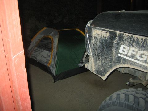 1990 Ford Bronco - green and gray dome tent set up beside the mud-splattered front fender of a truck wearing a BFGoodrich decal.