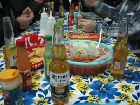 1990 Ford Bronco - table set with Corona Extra beer bottles, hot sauce, crackers and a bowl of food on a blue floral tablecloth.