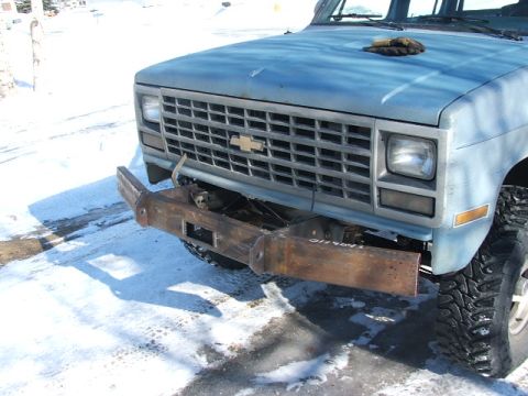1990 Chevrolet Suburban - Front view of a blue Chevrolet truck with a custom bumper and grille, parked in the snow.