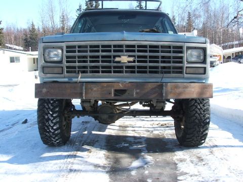 1990 Chevrolet Suburban - Front view of a 1990 Chevrolet Suburban, modified with a custom steel bumper and off-road tires.