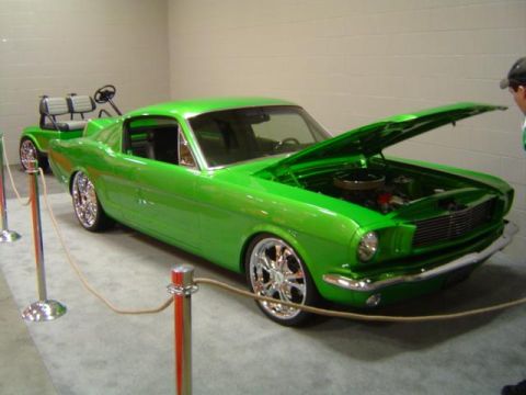 1979 Ford Bronco - A modified 1965 Ford Mustang is displayed with its hood open, alongside a golf cart.