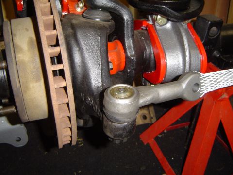1989 Ford Bronco - This image shows a close-up view of a vehicle's suspension and braking system components, including a brake rotor and steering linkage.