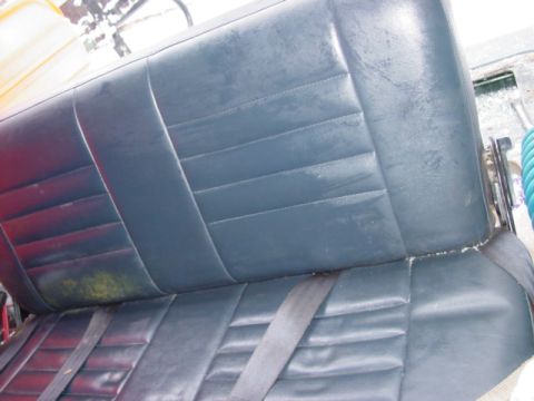 1986 Ford Bronco - A close-up view of a car's interior seat, showing its upholstery and seatbelt.