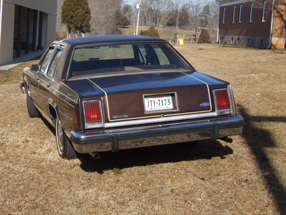 Brown Ford Crown Victoria sedan, rear view, showing chrome bumper and license plate JTY-7175