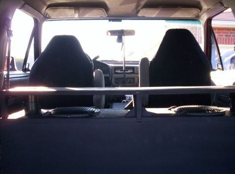 1995 Ford Bronco - The interior of a vehicle is shown, with a focus on the seats and dashboard area. A custom shelf is visible.