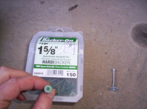 1995 Ford Bronco - A package of 15/8" screws for HardiBacker is shown next to a single screw on a concrete surface.