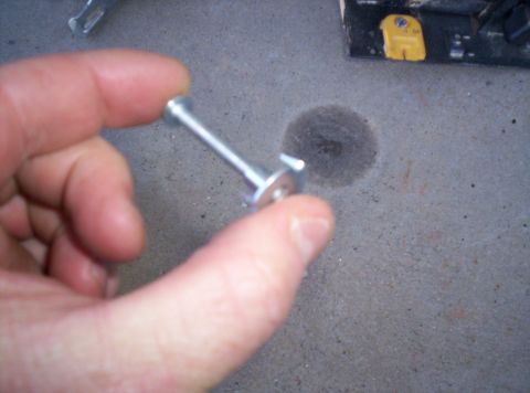 1995 Ford Bronco - A close-up of a metal fastener being held by fingers.