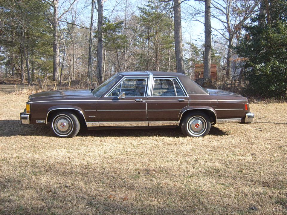 Brown sedan parked outside, side view. Looks like an 80s Ford sedan