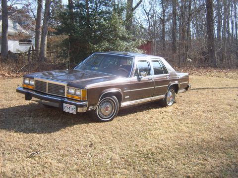 1982 Ford Crown Victoria LTD - This 1980s Ford sedan features a prominent chrome grille and a brown exterior.