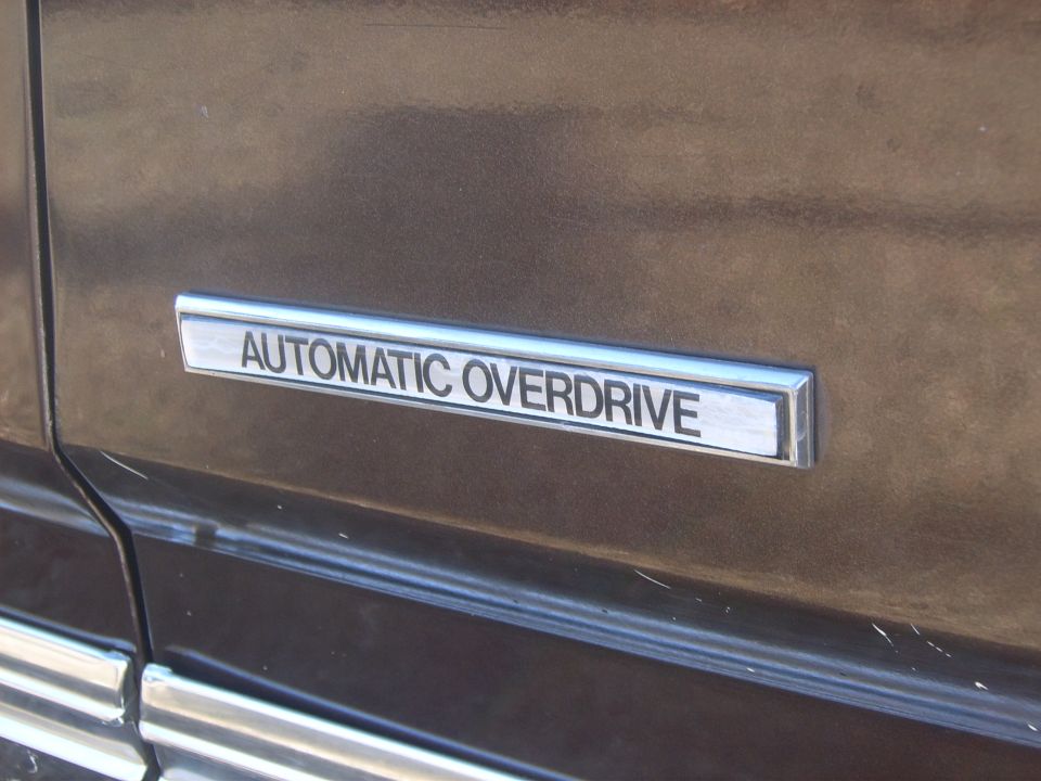 Automatic Overdrive badge on brown car side trim