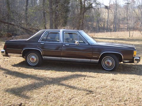 1982 Ford Crown Victoria LTD - Side profile of a 1982 Ford Crown Victoria LTD sedan in a rural setting.