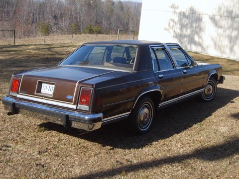 1982 Ford Crown Victoria LTD - Rear view of a brown sedan, likely from the early 1980s, parked on a grassy area.