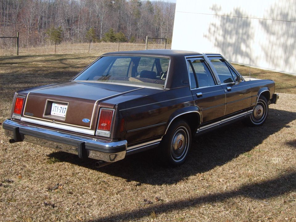 Brown sedan rear view with chrome bumper and license plate JTY-717