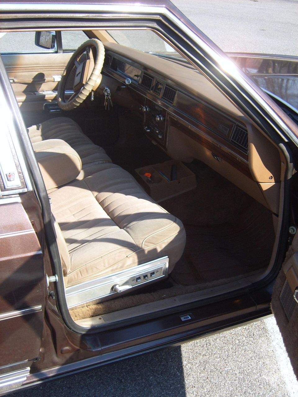 1982 Ford Crown Victoria LTD interior showing velour bench seat, wood-grain dash, and steering wheel