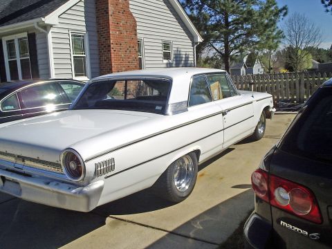 1963 Ford Galaxie - This white 1963 Ford Galaxie is seen from the rear 3/4 angle, chrome trim and custom wheels.