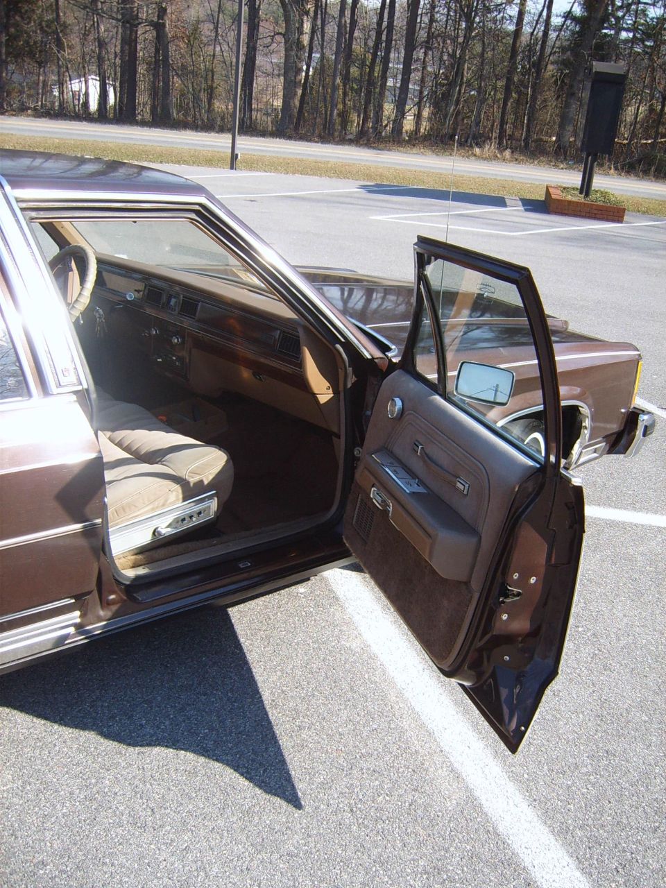 1982 Ford Crown Victoria LTD interior with open driver's door showing brown upholstery and dashboard