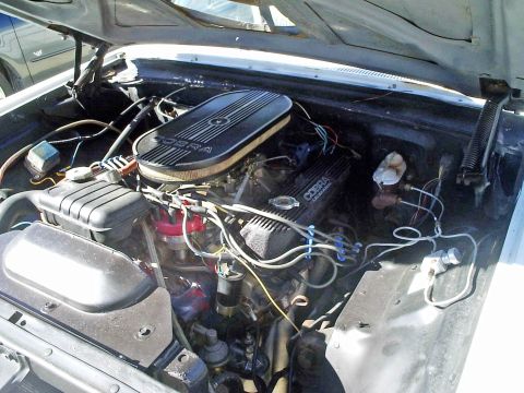 1963 Ford Galaxie - The engine bay of a 1963 Ford Galaxie features a Cobra engine with a distinctive air cleaner and valve covers.