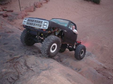 1996 Ford Bronco - A driver navigates a heavily modified truck over rough terrain.