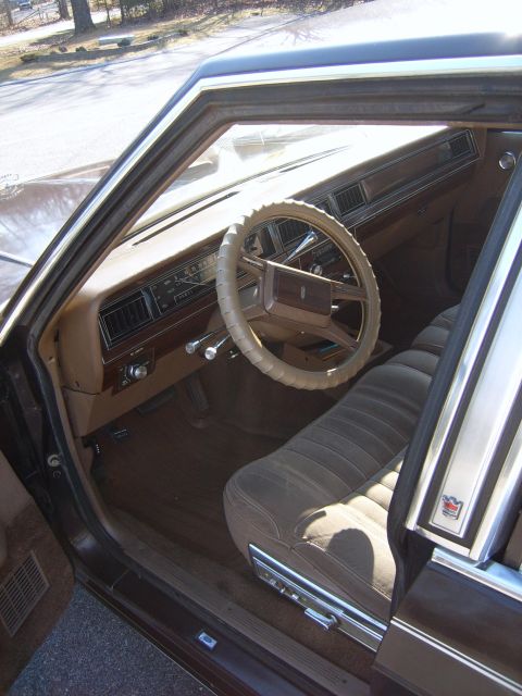 1982 Ford Crown Victoria LTD - The interior of a 1982 Ford Crown Victoria LTD features a brown dashboard, steering wheel, and striped seats.