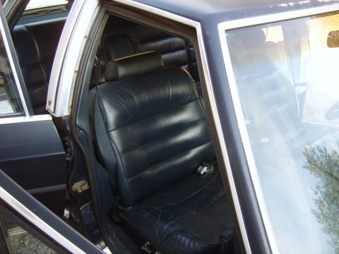 1982 Ford LTD Crown Victoria - Driver's door open on a dark blue car, looking down at the pleated navy vinyl split-bench front seat with pillow headrest and the rear benc…