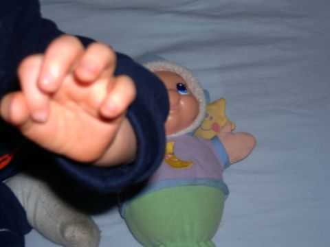 2006 Ford F1 - A baby's hand is in the foreground, reaching towards a stuffed toy that has a moon and star design.