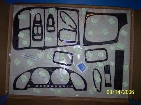 1995 Ford Probe - A box contains a carbon fiber interior trim kit with various pieces and protective packing material.