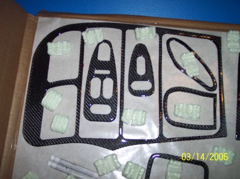 1995 Ford Probe - Carbon fiber trim pieces for a vehicle's interior are laid out on a surface, secured with packing material.