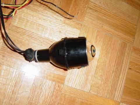 1993 Ford Probe - Headlight projector assembly with wiring, likely an aftermarket part, shown on a wooden surface.